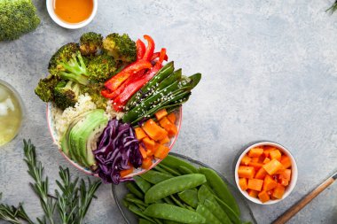 Kuskus, brokoli ve havuç pişmiş ile öğle yemeği için lezzetli sağlıklı kase küpleri, kızarmış bezelye, avokado ve kırmızı lahana kesmek. Kolay vejetaryen diyet kavramı. Rustik arka plan, kopya alanı.