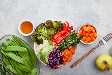 Kuskus, brokoli ve havuç pişmiş ile öğle yemeği için lezzetli sağlıklı kase küpleri, kızarmış bezelye, avokado ve kırmızı lahana kesmek. Kolay vejetaryen diyet kavramı. Rustik arka plan, kopya alanı.