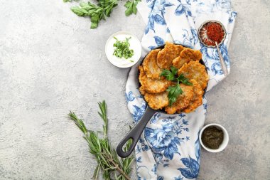 Patates Latkeler geleneksel Yahudi krep ekşi krema, maydanoz, kuru kırmızı pul biber ve nane sosu ile. Arka plan, beyaz mavi çiçekli peçete. Hannukah kutlama yemeği kavramı. Kopya alanı.