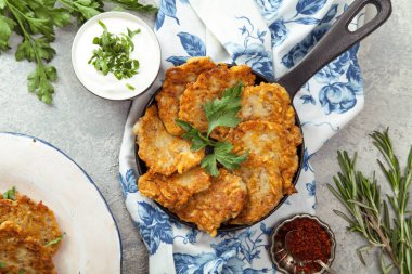 Patates Latkeler geleneksel Yahudi krep ekşi krema, maydanoz, kuru kırmızı pul biber ve nane sosu ile. Arka plan, beyaz mavi çiçekli peçete. Hannukah kutlama yemeği kavramı.
