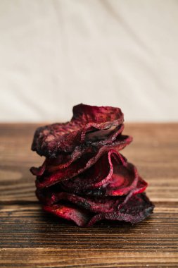Organik ev yapımı pancar cips ahşap masanın üzerinde yatan zeytinyağı ile pişirilmiş yakın çekim 
