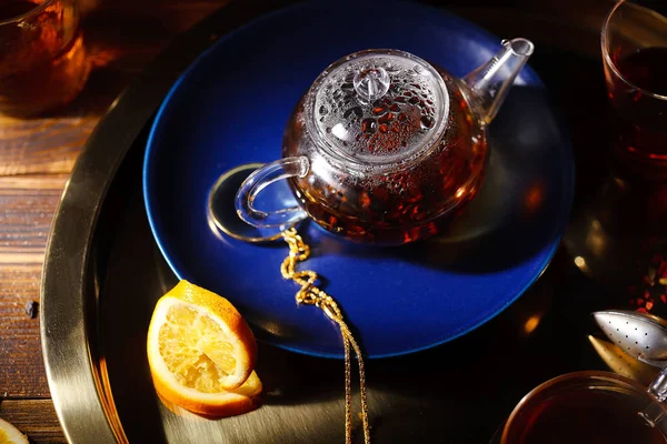 Небольшой Стеклянный Чайник Горячим Черным Чаем Апельсиновыми Ломтиками Золотом Подносе — стоковое фото