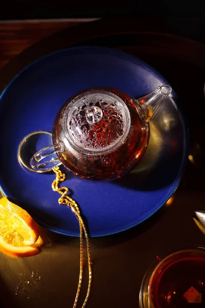 Небольшой Стеклянный Чайник Горячим Черным Чаем Апельсиновыми Ломтиками Золотом Подносе — стоковое фото