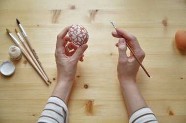 erkek çeşitli beyaz desenler ile boyama yumurta Paskalya tatili için eller.