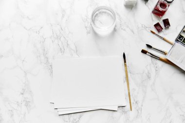 Sanatçı işyeri suluboya kağıdı ve Boya fırçaları ve su, üstten görünüm ile sahte