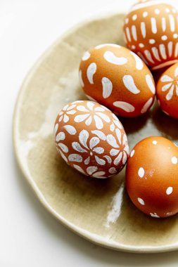 Beyaz arka plan üzerinde Paskalya tatil kavramı izole çeşitli desenler ile beyaz boyalı yumurta ile plaka 