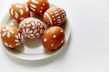 Beyaz arka plan üzerinde Paskalya tatil kavramı izole çeşitli desenler ile beyaz boyalı yumurta ile plaka 