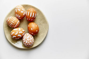 Beyaz arka plan üzerinde Paskalya tatil kavramı izole çeşitli desenler ile beyaz boyalı yumurta ile plaka    