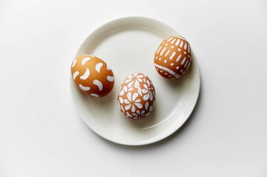 Beyaz arka plan üzerinde Paskalya tatil kavramı izole çeşitli desenler ile beyaz boyalı yumurta ile plaka  