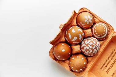 renkli portakal karton konteyner, Paskalya tatil kavramı çeşitli beyaz desenler boyalı yumurta  