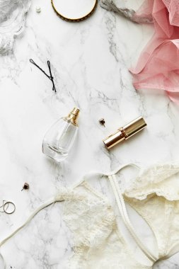 parfüm ve takı öğeleri beyaz mermer zemin, güzellik rutin kavramı üzerine rujla kadın dantel iç çamaşırı