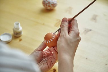 Dişi yumurta Paskalya tatili, yakın çekim için beyaz desen boya eller    