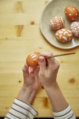 Dişi yumurta Paskalya tatili, yakın çekim için beyaz desen boya eller   
