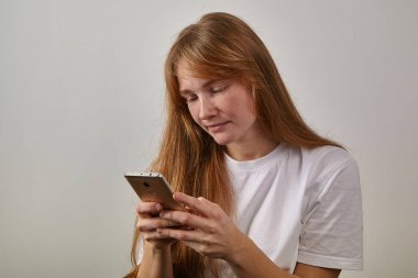 Kızıl saçlı olan kadın telefon elinde tutan ve metin mesajları okuma çiller