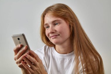 Kızıl saçlı olan kadın telefon elinde tutan ve metin mesajları okuma çiller