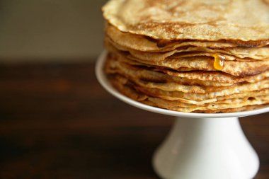 Krep pasta ve karanlık arka planlı, ahşap masa üzerinde bal ile portakal reçeli ile beyaz pasta stand yakın çekim 