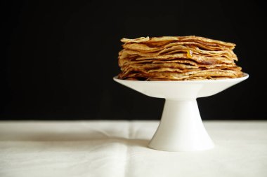 Krep pasta ve bal koyu arka plan, tablo ile portakal reçeli ile beyaz pasta stand yakın çekim 