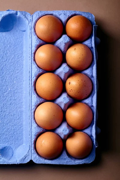 close-up with dozen of chicken eggs in colorful violet cardboard container