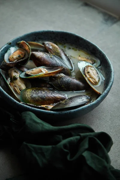 kivi midye marnier ve maydanoz el yapımı mavi seramik plaka gri arka plan üzerinde beyaz şarap soslu pişmiş 
