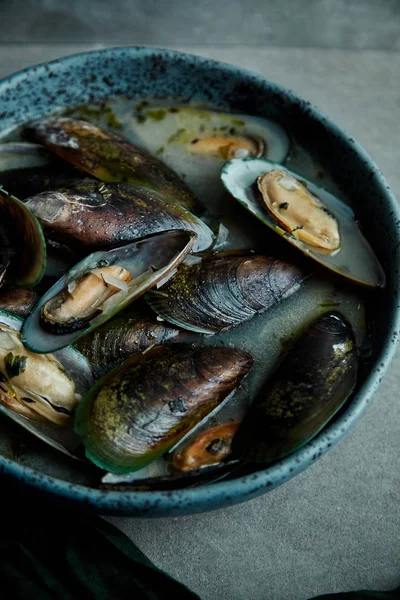 kivi midye marnier ve maydanoz el yapımı mavi seramik plaka gri arka plan üzerinde beyaz şarap soslu pişmiş 
