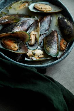 kivi midye marnier ve maydanoz el yapımı mavi seramik plaka gri arka plan üzerinde beyaz şarap soslu pişmiş 