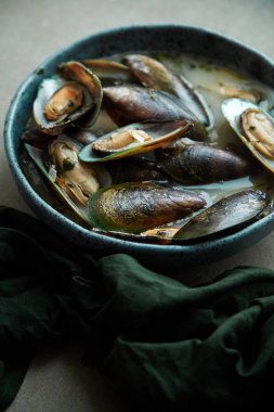 kivi midye marnier ve maydanoz el yapımı mavi seramik plaka gri arka plan üzerinde beyaz şarap soslu pişmiş 