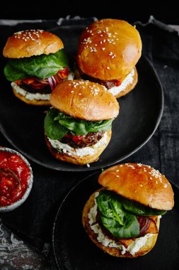 eski ahşap masa, ıslak zeminde sos ile plakalar Burgers yakın çekim 