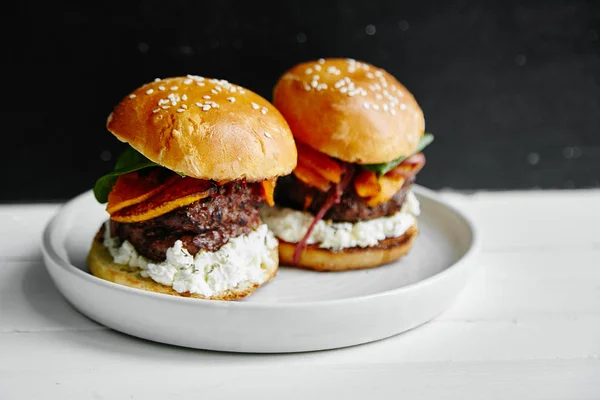 Beyaz ahşap masa, burgers ile seramik tabak yakın çekim 