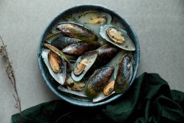 kivi midye marnier ve maydanoz el yapımı mavi seramik plaka gri arka plan üzerinde beyaz şarap soslu pişmiş 