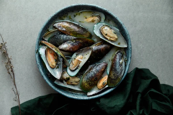 kivi midye marnier ve maydanoz el yapımı mavi seramik plaka gri arka plan üzerinde beyaz şarap soslu pişmiş 