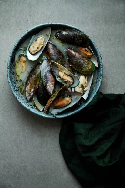 kivi midye marnier ve maydanoz el yapımı mavi seramik plaka gri arka plan üzerinde beyaz şarap soslu pişmiş 