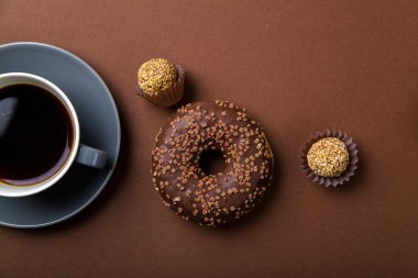 domalan ve siyah kahve kahverengi arka planda, tek renkli kavramı ile çikolatalı çörek 