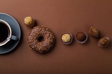 domalan ve siyah kahve kahverengi arka planda, tek renkli kavramı ile çikolatalı çörek 