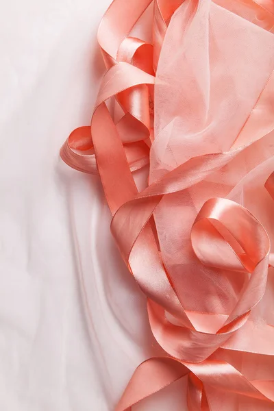 白色纺织背景上的透明织物光泽粉红色缎带 — 图库照片