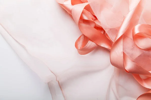 白色纺织背景上的透明织物光泽粉红色缎带 — 图库照片