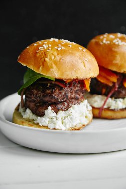 Beyaz ahşap masa, burgers ile seramik tabak yakın çekim 