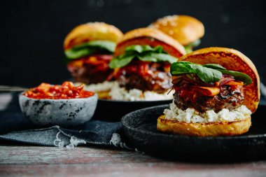 ahşap masa, ıslak zeminde sos ile plakalar Burgers yakın çekim 