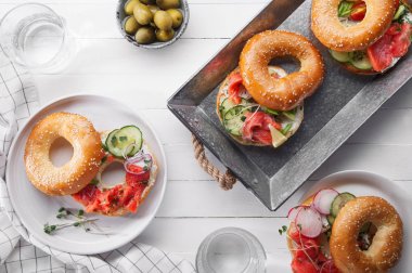 simit Somon Balık ve salatalık ve tepsi ve kaplamalar, yakın çekim taze turp dilimleri ile krem peynir ile 