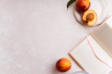 pastel pembe arka plan: Not defteri ve meyve atıştırmalıklar ile kadın çalışma alanı 