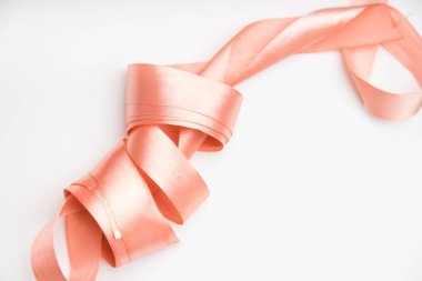 pembe ipek kurdele bobin gergin beyaz zemin üzerine izole köşegen olarak yakın çekim 