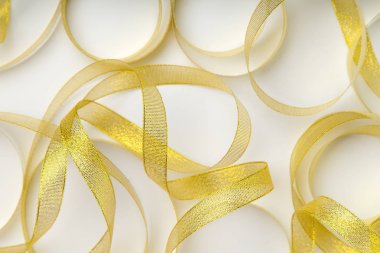 beyaz zemin üzerine spiral düzende soluksuz parlak altın şeritler 