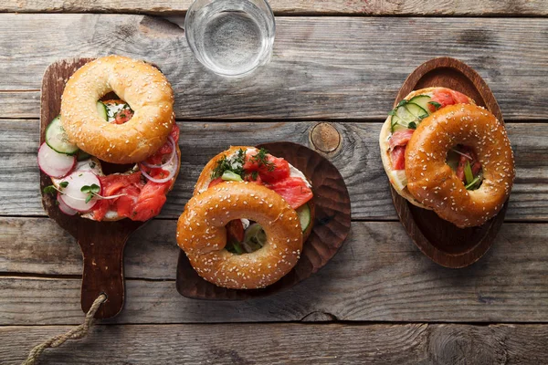 Somon Balık simit ve salatalık ve ahşap taze turp dilimleri ile krem peynir kesme panoları, yakın çekim 