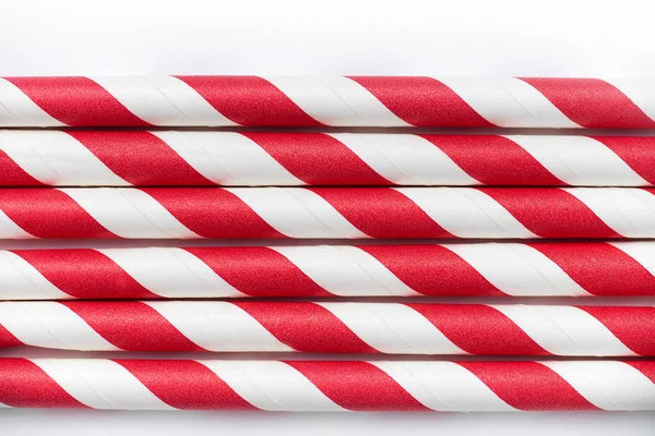 pile of red and white party drinking straws isolated on white background, close-up