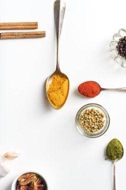 Beyaz arka plan üzerinde izole kaşık içinde renkli Ortadoğu baharatlar yakın çekim 