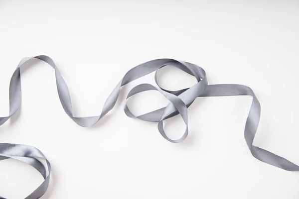 Curled Gray Silk Ribbon White Background Copy Space — Stock Photo, Image