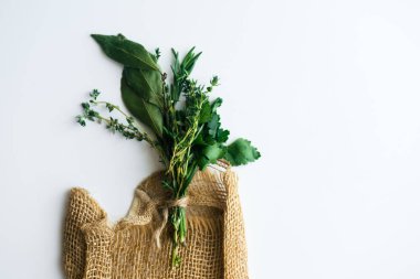 buket garni defne yaprakları ve beyaz arka plan üzerinde izole rustik havlu üzerinde taze otlar ile yakın çekim 