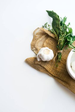 buket garni defne yaprağı ve harcı ve havaneli beyaz zemin üzerine izole rustik havlu üzerinde taze otlar ile yakın çekim 
