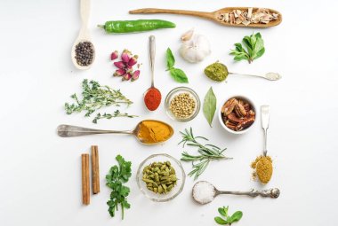 Taze ot ve kaşık ve beyaz arka plan üzerinde geometrik olarak düzenlenmiş kase kuru renkli baharat