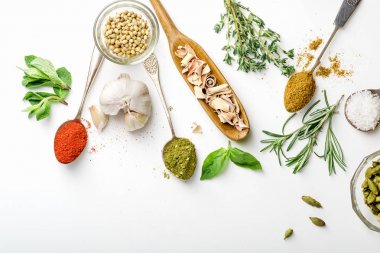 Taze ot ve kaşık ve bir tarafta kopya alanı ile düzenlenmiş kase kuru renkli baharat 