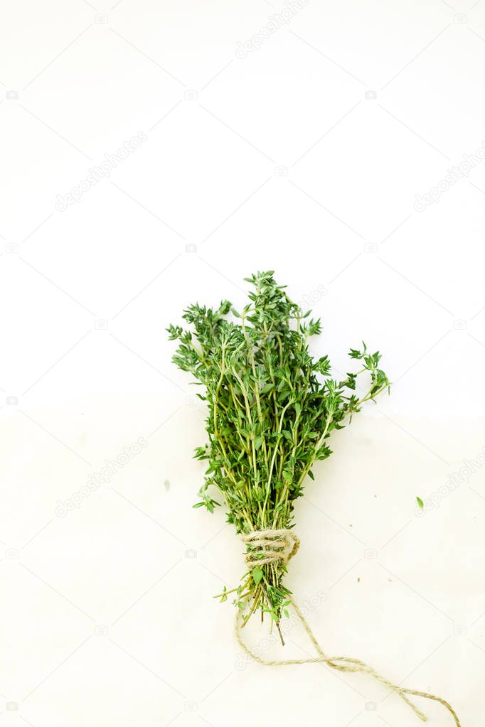 Bunch of fresh thyme leaves tied with string on white background with text space